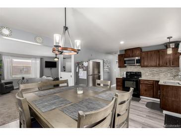 Charming kitchen featuring a dining table with pendant lighting and stainless steel appliances at 117 6Th St, Frederick, CO 80530