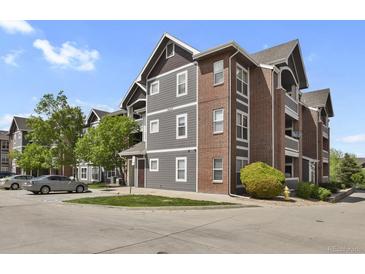 Attractive building with red brick and grey siding, manicured lawn and parking area visible at 14353 E 1St Dr # 302, Aurora, CO 80011