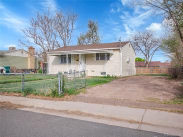 Quaint single-story home featuring a partially fenced yard and off-street parking at 7881 Kenwood St, Commerce City, CO 80022