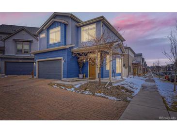 Charming two-story home features blue siding, a covered porch, and an attached garage at 17950 E 54Th Ave, Denver, CO 80249