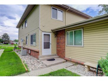 Charming townhome featuring a welcoming front entrance, complemented by a well-maintained lawn and landscape at 3355 S Flower St # 166, Lakewood, CO 80227