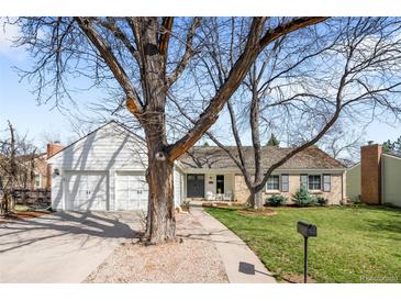 Charming brick home with a well-manicured lawn, mature trees, and a welcoming front entrance at 6997 S Poplar Way, Centennial, CO 80112