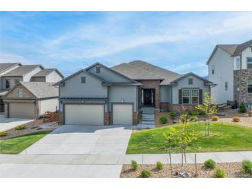 Charming home featuring a well-manicured lawn and a spacious three car garage at 18212 W 95Th Pl, Arvada, CO 80007