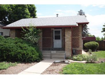 Charming brick home featuring a well-maintained front yard and covered entryway at 2902 Depew St, Wheat Ridge, CO 80214