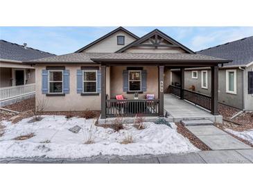 Charming home featuring a cozy front porch with seating, complemented by stylish blue shutters on the windows at 692 Sage Forest Ln, Monument, CO 80132