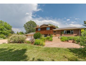 Charming two-story home with a well-manicured lawn, mature trees, and beautiful landscaping creating an inviting curb appeal at 8836 Marathon Rd, Longmont, CO 80503