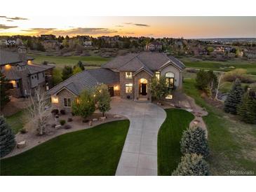 Beautiful home exterior with manicured lawn and long driveway leading up to a stone and stucco facade at 5409 Sedona Dr, Parker, CO 80134