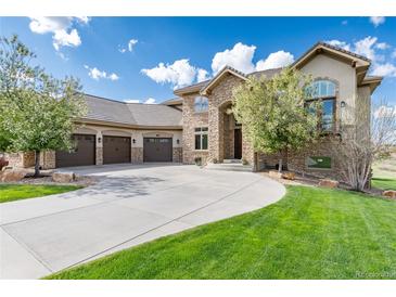 Stunning stone home with a three-car garage and a beautifully landscaped front yard with a circular driveway at 5409 Sedona Dr, Parker, CO 80134