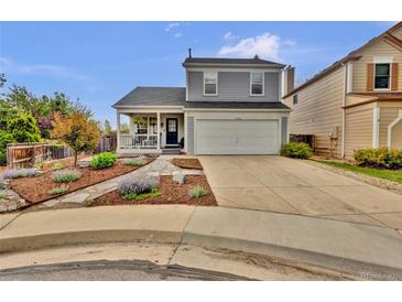 Charming two-story home with a covered front porch, two-car garage, and well-manicured landscaping at 14430 W Yale Pl, Lakewood, CO 80228