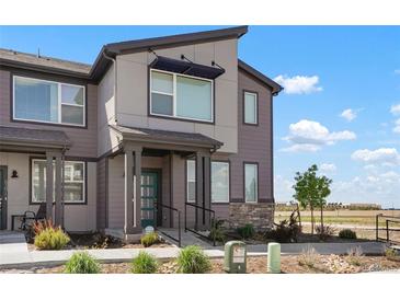Charming exterior view of townhome with landscaped front yard, modern colors, and inviting entryway at 6393 N Malaya St, Aurora, CO 80019