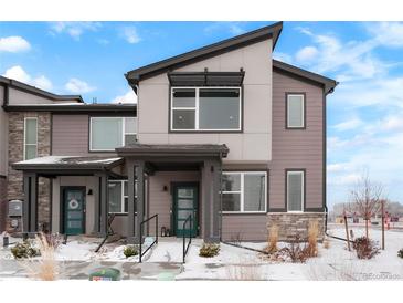 Modern townhome with a neutral color scheme, partial stone accents and a covered front entryway at 6393 N Malaya St, Aurora, CO 80019