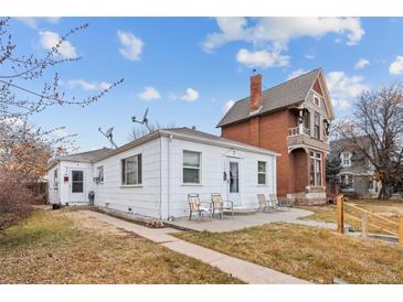 White bungalow home with a spacious yard and detached garage at 2229 S Bannock St, Denver, CO 80223