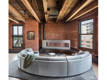 Beautiful living room with exposed brick, wood ceilings and modern fireplace at 1628 14Th St # 6A, Denver, CO 80202