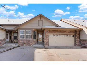 Inviting exterior showcasing a two-car garage and charming stone accents at 23590 E Jamison Pl, Aurora, CO 80016
