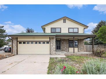Charming two-story home with stone accents, a two-car garage, and a well-maintained front yard at 14190 E Gunnison Pl, Aurora, CO 80012