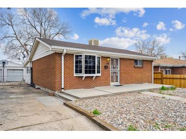 Charming brick home featuring a well-maintained lawn and a cozy front porch area at 860 Zenobia St, Denver, CO 80204