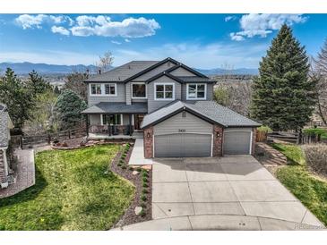 Stunning two-story home features a three-car garage, manicured lawn, and mountain views at 7411 S Curtice Ct, Littleton, CO 80120
