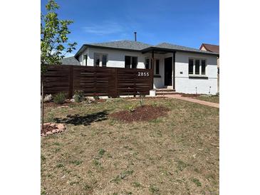 Charming single-story home featuring a modern horizontal fence and freshly landscaped front yard with walkway at 2855 Albion St, Denver, CO 80207