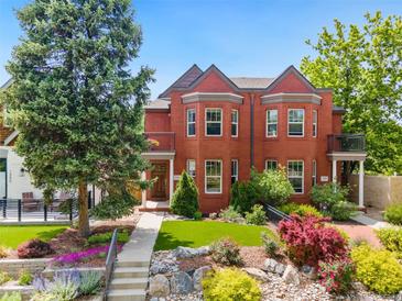 Stunning red brick home features a manicured lawn and beautiful landscaping, providing inviting curb appeal at 1551 S Grant St, Denver, CO 80210