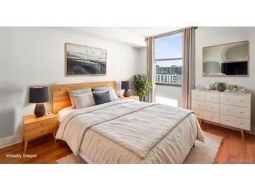 Bright bedroom with modern furniture, a large window with city views, and stylish decor at 1301 Speer Blvd # 702, Denver, CO 80204