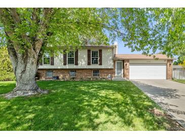 Charming two-story home with a well-manicured lawn and a two-car garage at 11199 Dahlia Pl, Thornton, CO 80233