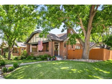 Charming brick home with a lush green lawn and mature trees providing ample shade and curb appeal at 2604 Elm St, Denver, CO 80207