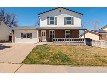 Charming two-story home featuring a welcoming front porch and well-maintained lawn at 10415 Owens Cir, Broomfield, CO 80021