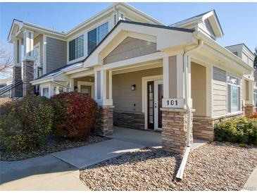 Inviting condo entrance featuring stone accents, well-kept landscaping, and a welcoming porch at 13708 Legend Trl # 101, Broomfield, CO 80023