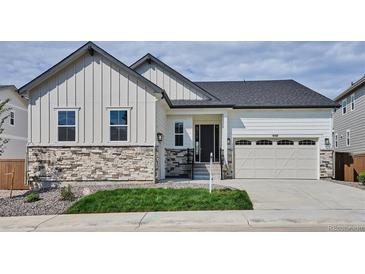 Charming exterior featuring stone accents, white siding, and a two-car garage at 9197 Ironwood St, Highlands Ranch, CO 80129