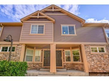 Charming townhouse with stone accents, covered entryway, neutral paint, and beautiful blue sky at 5660 S Algonquian Way # A, Aurora, CO 80016