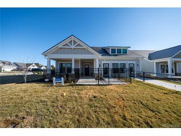 Charming single-story home with a covered porch and black metal fence on a sunny day at 367 Josef Cir, Fort Lupton, CO 80621