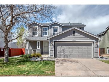 Charming two-story home featuring a gray exterior, well-maintained lawn, and an attached two-car garage at 5237 S Malaya Way, Centennial, CO 80015