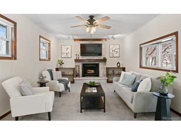 Inviting living room with fireplace, exposed brick, and plenty of natural light at 3190 Ward Ct, Wheat Ridge, CO 80215