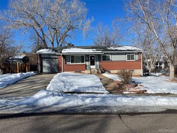 Brick ranch home with attached garage and snow-covered yard at 12289 W Dakota Dr, Lakewood, CO 80228