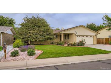 Charming one-story home featuring a well-manicured lawn and vibrant flowerbeds at 3544 Dyanna Dr, Thornton, CO 80241