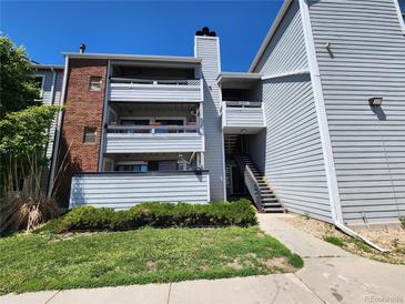 Two-story condo with light-blue siding, red brick accents, and a well-maintained grassy lawn and shrubs at 14499 E 1St Dr # A05, Aurora, CO 80011