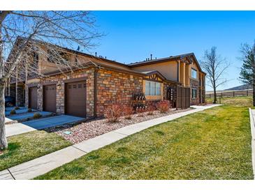 Beautiful two-story townhouse with brick and siding exterior and attached garages on a sunny day at 9816 W Freiburg Dr # A, Littleton, CO 80127