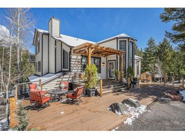 Beautiful home exterior with a wooden deck, pergola, and cozy seating area, perfect for enjoying the outdoors at 846 Circle K Ranch Rd, Evergreen, CO 80439