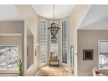 Bright foyer with glass block windows, high ceilings, and modern chandelier at 846 Circle K Ranch Rd, Evergreen, CO 80439
