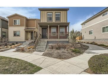 Charming two-story home featuring a covered porch and landscaped front yard at 12770 Tamarac St, Thornton, CO 80602
