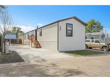 Charming single-story home with a well-manicured lawn, new concrete driveway, and appealing exterior paint at 8497 Madison Way, Denver, CO 80229