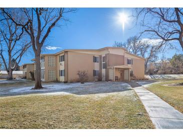 Two-story brick apartment building featuring a well-maintained lawn and sidewalk at 765 S Alton Way # 6B, Denver, CO 80247