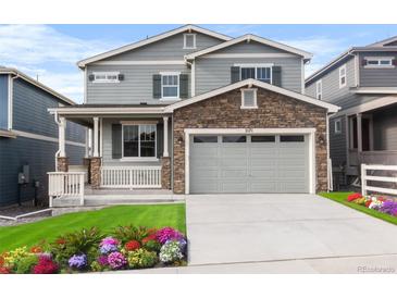 Charming two-story home with stone accents, a well-manicured lawn, and a welcoming front porch at 4543 Cholla Trl, Castle Rock, CO 80104