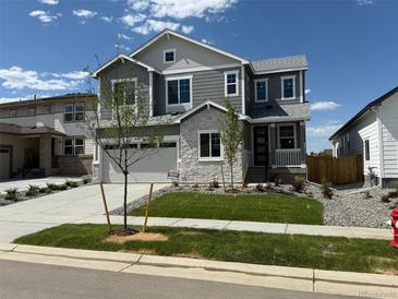Beautiful two-story home featuring stone accents, manicured lawn, and attached two-car garage at 1131 Joseph Pl, Erie, CO 80026
