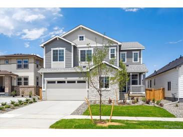 Beautiful two-story home featuring stone accents, a gray exterior, manicured lawn and attached two-car garage at 1131 Joseph Pl, Erie, CO 80026
