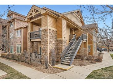 Condo exterior shows a brown multi-story building with stone accents and metal staircase at 10056 W Unser Dr # 204, Littleton, CO 80127