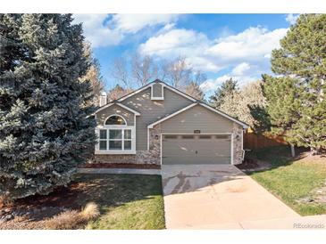 Charming home features a front lawn, attached garage and stone accents at 21593 Hill Gail Way, Parker, CO 80138