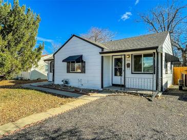 White house with black accents, landscaping, and a gravel driveway at 886 Kenton St, Aurora, CO 80010