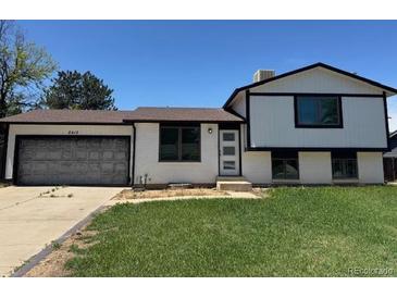 Charming two-story home with a well-maintained lawn and a convenient attached garage at 2513 S Crystal St, Aurora, CO 80014