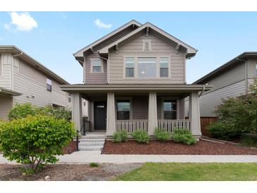 Charming two-story home with a cozy front porch and well-maintained landscaping at 5716 Boston Ct, Denver, CO 80238